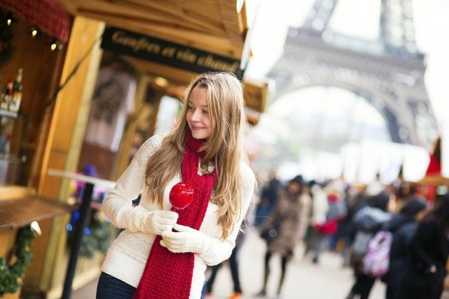 16010106-Happy young girl with caramel apple on a Parisian Christmas market with the Eiffel tower
